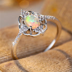 Opal Ring mit ovalem Mittelstein und Ornamentrahmen