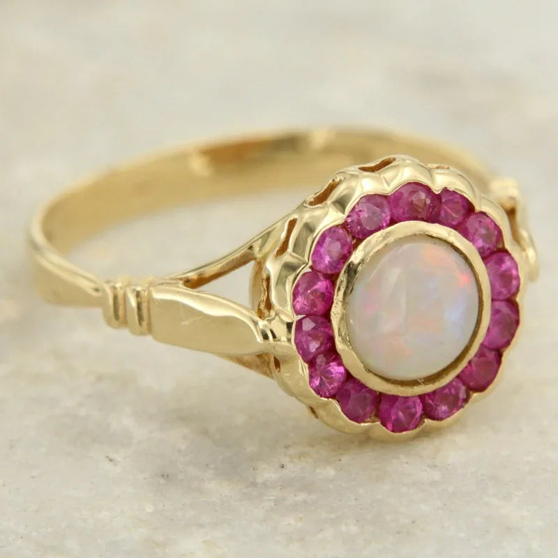 Opal Ring mit rundem Mittelstein und rotem Steinrahmen