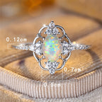 Opal Ring mit ovalem Mittelstein und Ornamentrahmen