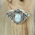 Opal Ring mit rundem Stein und Flechtrahmen