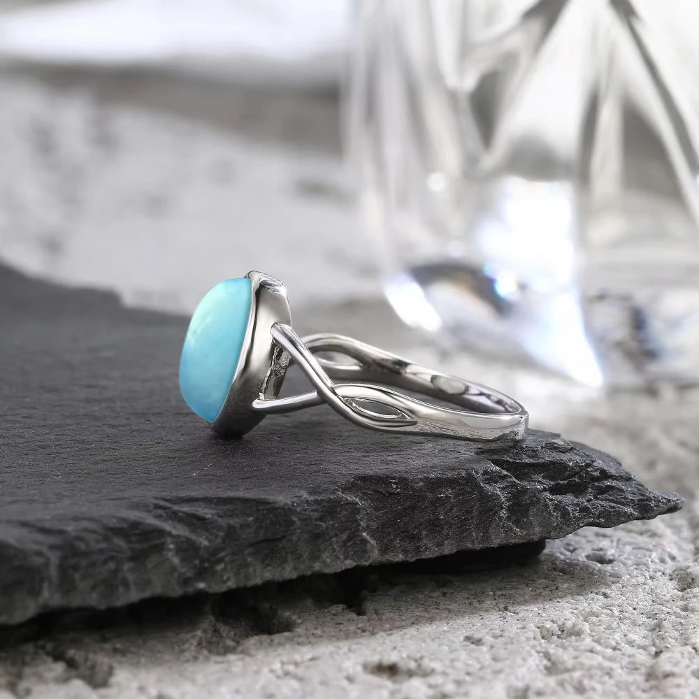 Aquamarin Cabochonring mit ovalem Stein und gekreuzter Ringschiene