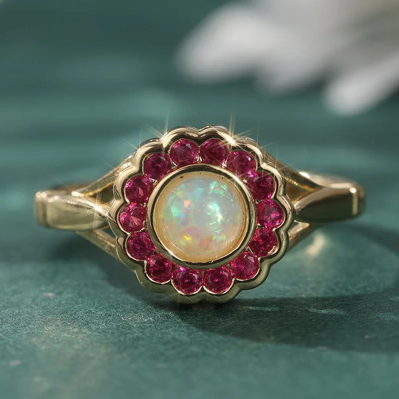 Opal Ring mit rundem Mittelstein und rotem Steinrahmen