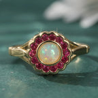 Opal Ring mit rundem Mittelstein und rotem Steinrahmen