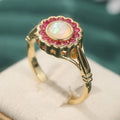 Opal Ring mit rundem Mittelstein und rotem Steinrahmen
